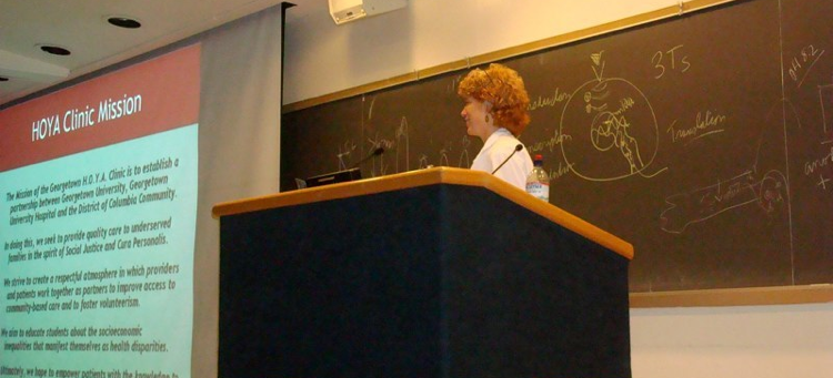A medical school doctor lecturing in front of a blackboard.