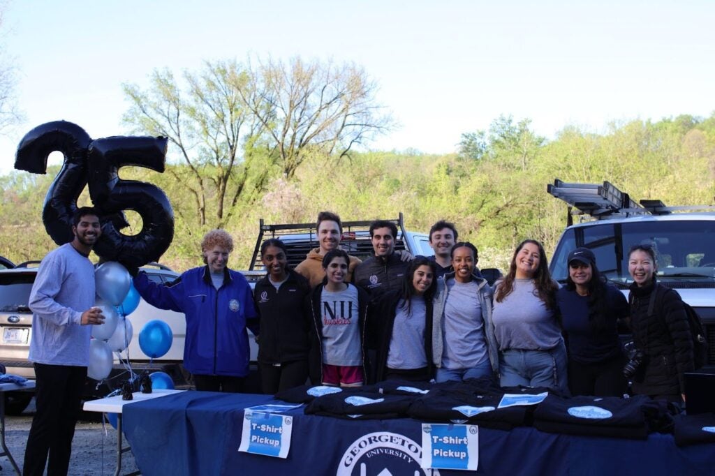 Group of volunteers smiling outside tabling at IronMed