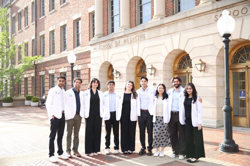 Image of 9 HOYA Clinic Coordinators standing in front of MedDent building